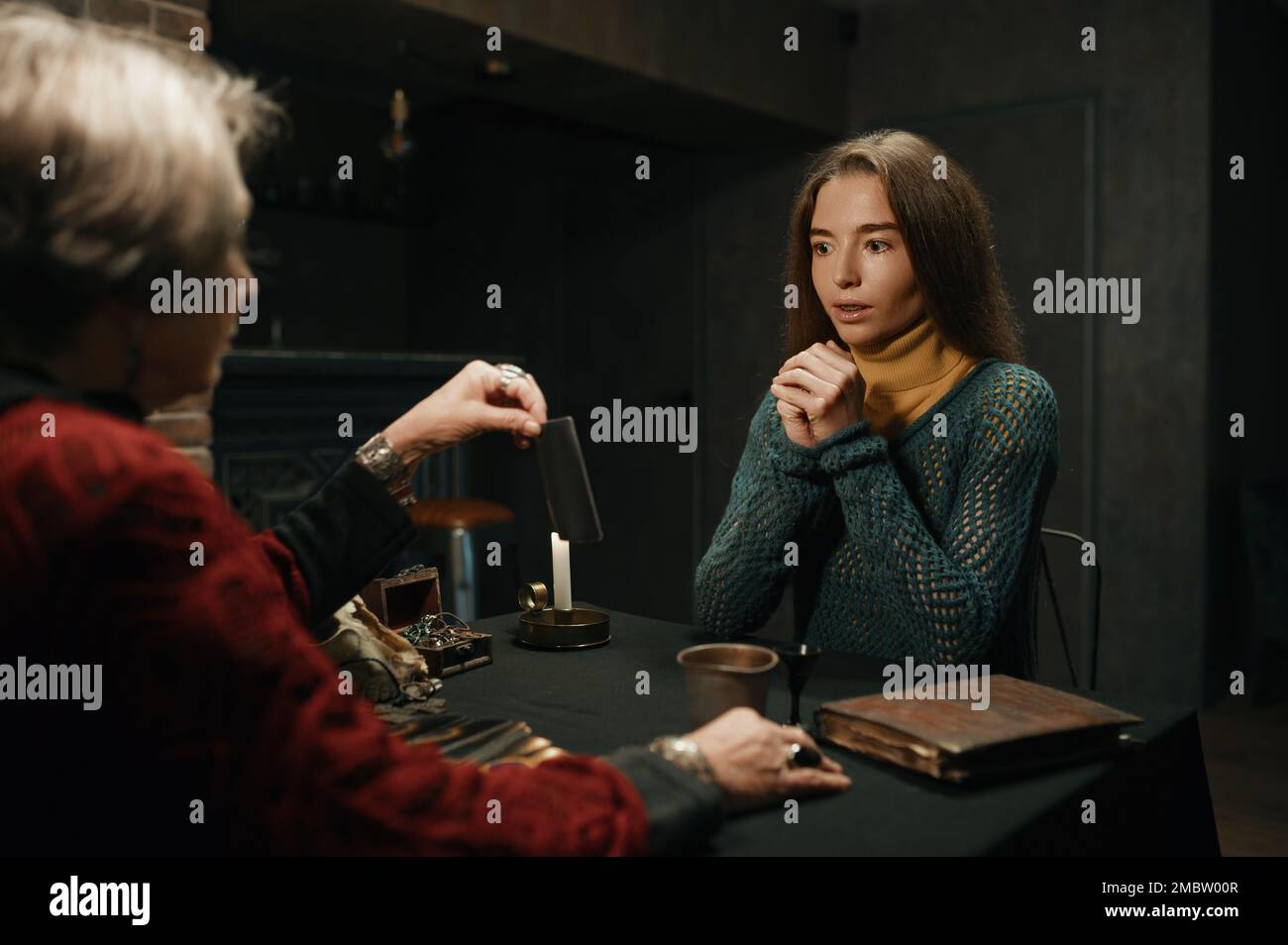 Zigeunerhexe liest Tarotkarten für junge Besucherinnen Stockfoto