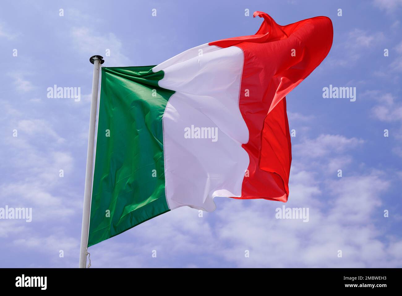 italienische Flagge italienisch schwimmt in Matte mit Wind am Wolkenhimmel Stockfoto