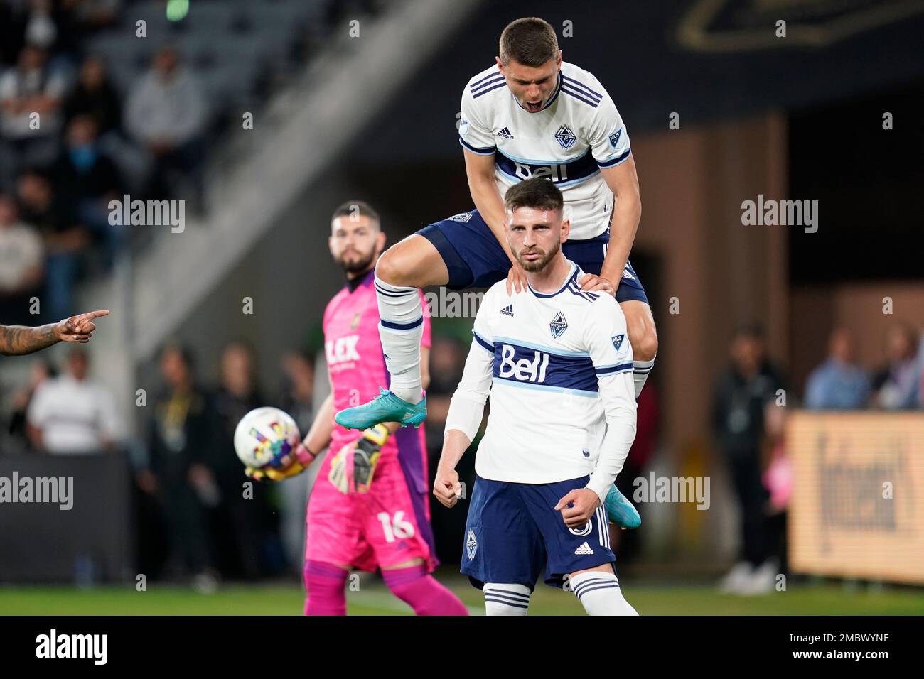 Vancouver Whitecaps defender Ranko Veselinović, top, celebrates with defender Tristan Blackmon (6) after Blackmon scored during the first half of an MLS soccer match against the Los Angeles FC in Los Angeles, Sunday, March 20, 2022. Los Angeles FC goalkeeper Maxime Crépeau (16) reacts. (AP Photo/Ashley Landis) Stockfoto
