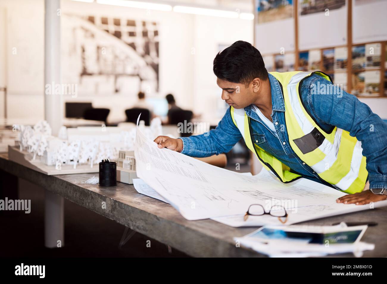 Niemand plant besser als er. Ein junger Architekt, der sich einen Plan in seinem Büro ansieht. Stockfoto