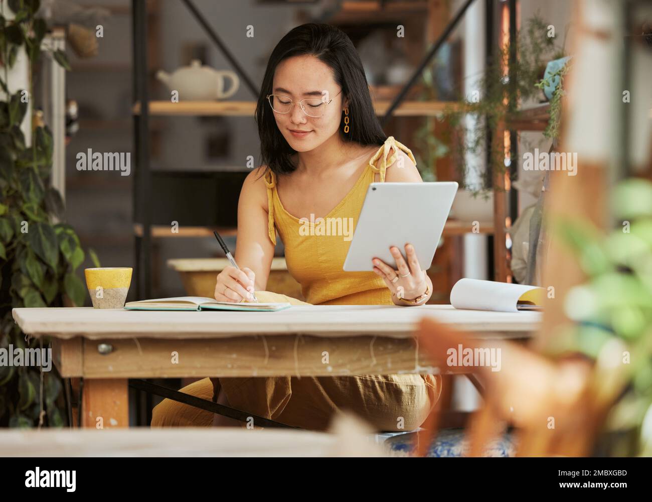 Denken, Recherchen und Tablet mit einer asiatischen Frau, die im Start-up-Unternehmen für Management, Planung oder Ziele in Notizbücher schreibt. Idee, Vision und kreativ mit Klein Stockfoto
