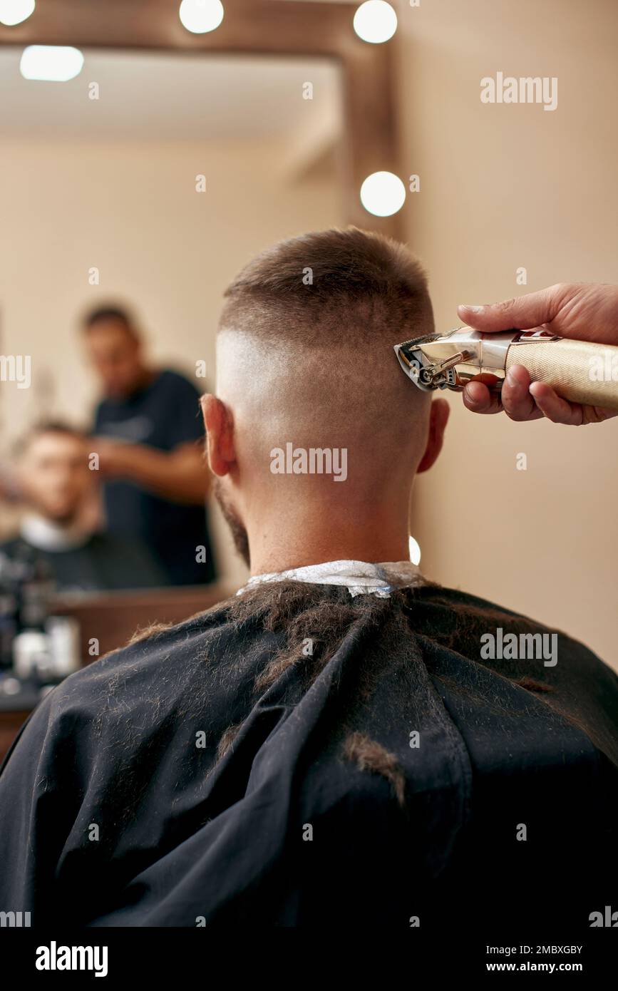 Friseur rasierender Weißer im Friseursalon Stockfoto