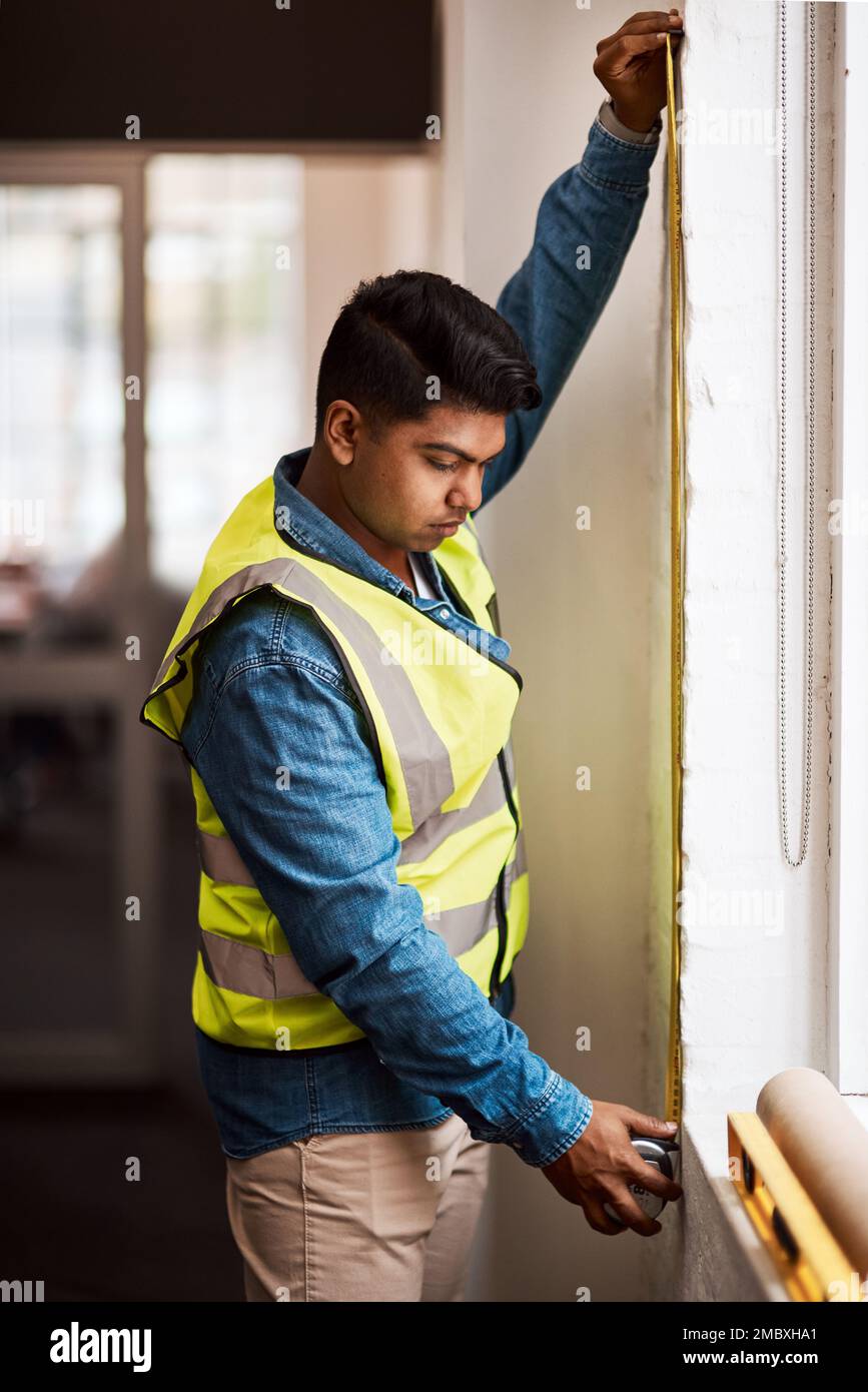 Messungen sind entscheidend für eine gute Konstruktion. Ein Ingenieur, der Messungen auf einer Baustelle durchführt. Stockfoto