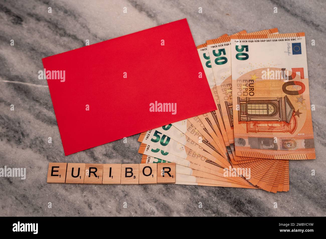 Word EURIBOR ist in Holzbuchstaben geschrieben, in der Nähe von 50 Euro-Banknoten und rotem Umschlag. Stockfoto