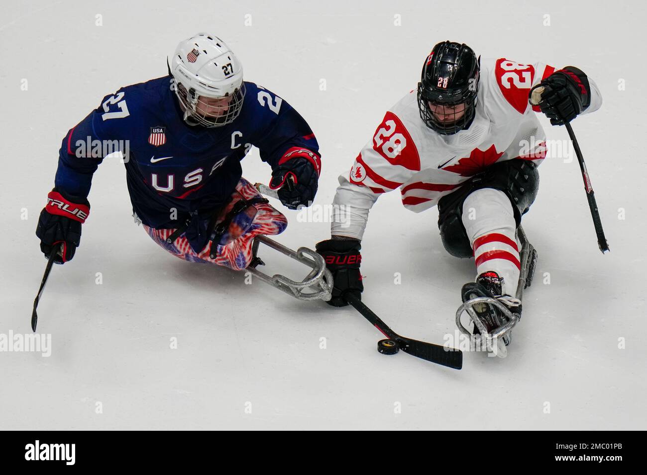 Antoine Lehoux, right, of Canada and Josh Paul of the United States battle for the puck during their para ice hockey gold medal match between the United States and Canada at the 2022 Winter Paralympics, Sunday, March 13, 2022, in Beijing. (AP Photo/Shuji Kajiyama) Stockfoto