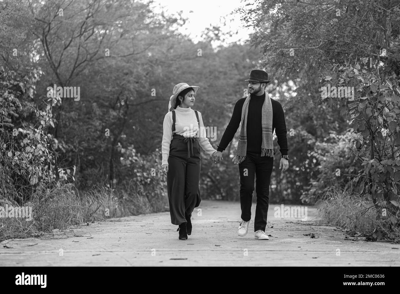 Vor der Hochzeit wurde ein indisches Paar auf dem Weg der Natur in Delhi, Indien, aufgenommen. Romantisches Paar Shoot. Braut und Bräutigam im natürlichen Wald mit Bäumen. Stockfoto