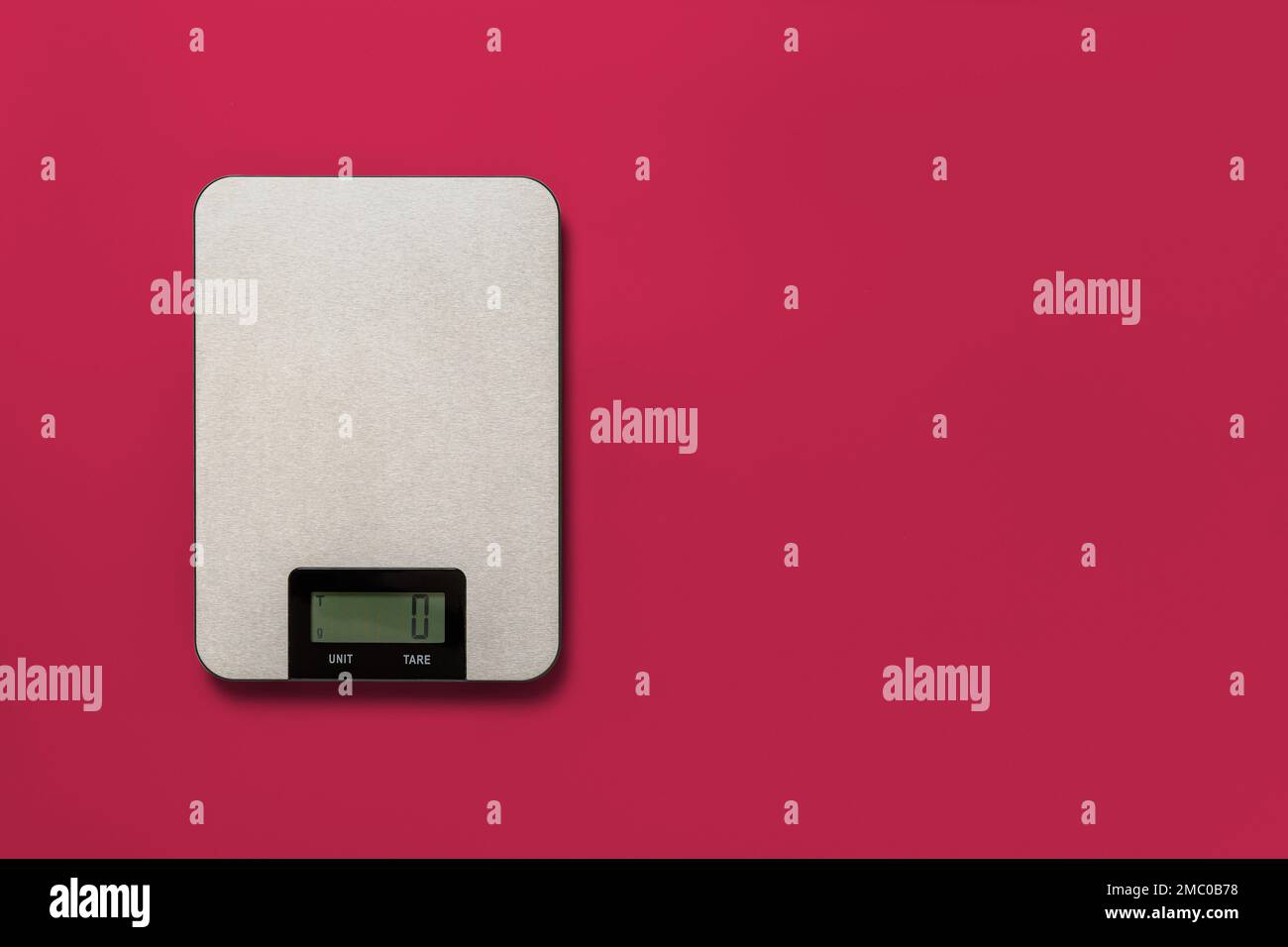 Digitale Küchenwaage über Viva Magenta-Hintergrund. Elektronische Waagen zur Gewichtsmessung von Lebensmitteln. Design-Element für Diät und Kochen. Speicherplatz kopieren Stockfoto