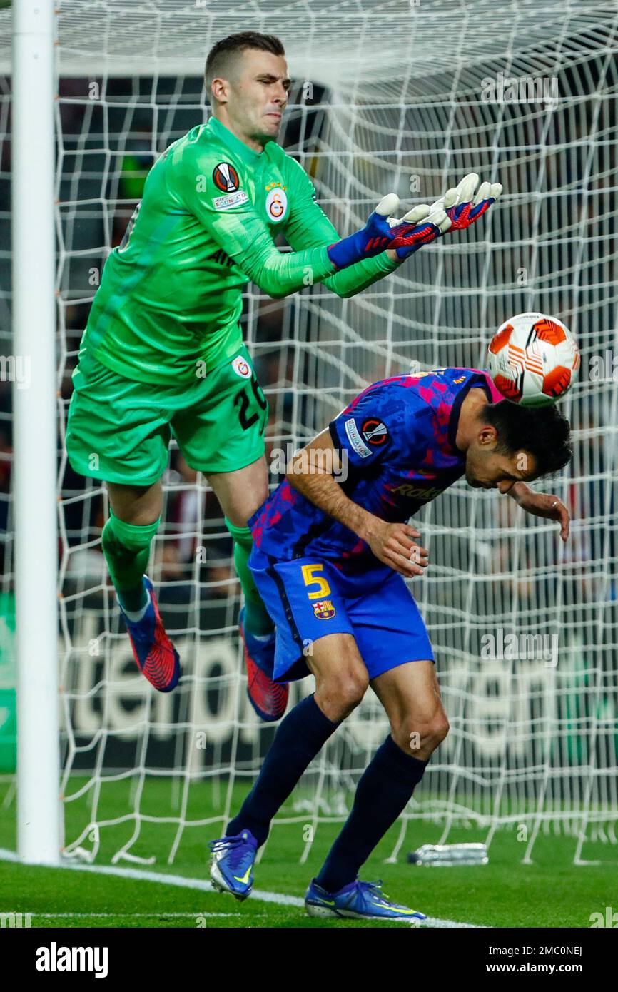 Galatasaray's goalkeeper Inaki Pena, left, fights for the ball with Barcelona's Sergio Busquets during the Europa League, round of 16, first leg soccer match between FC Barcelona and Galatasaray at the Camp Nou stadium in Barcelona, Spain, Thursday, March 10, 2022. (AP Photo/Joan Monfort) Stockfoto