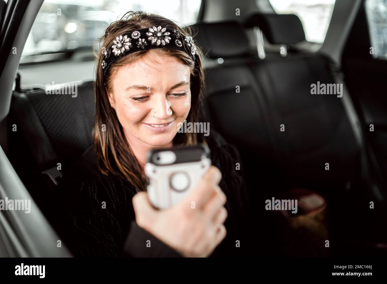 Ein Taxi oder ein Uber-Passagier, der über das Telefon auf dem Rücksitz des Autos spricht Stockfoto