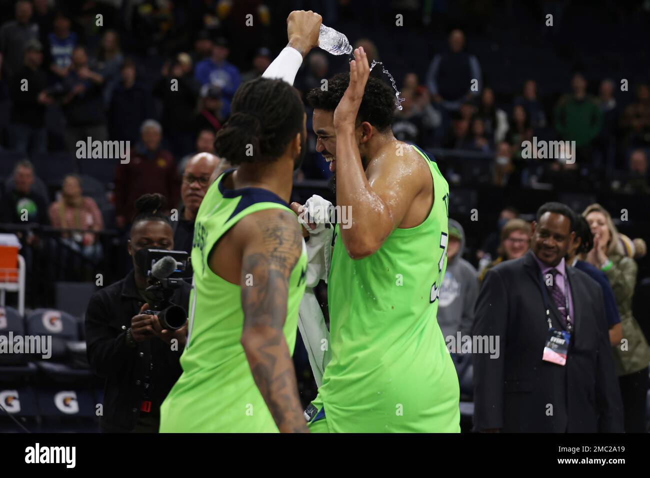 Minnesota Timberwolves guard D'Angelo Russell, left, dumps a bottle of water over center Karl-Anthony Towns in celebration of the team's 135-121 against the Portland Trail Blazers in an NBA basketball game Saturday, March 5, 2022, in Minneapolis. (AP Photo/Stacy Bengs) Stockfoto