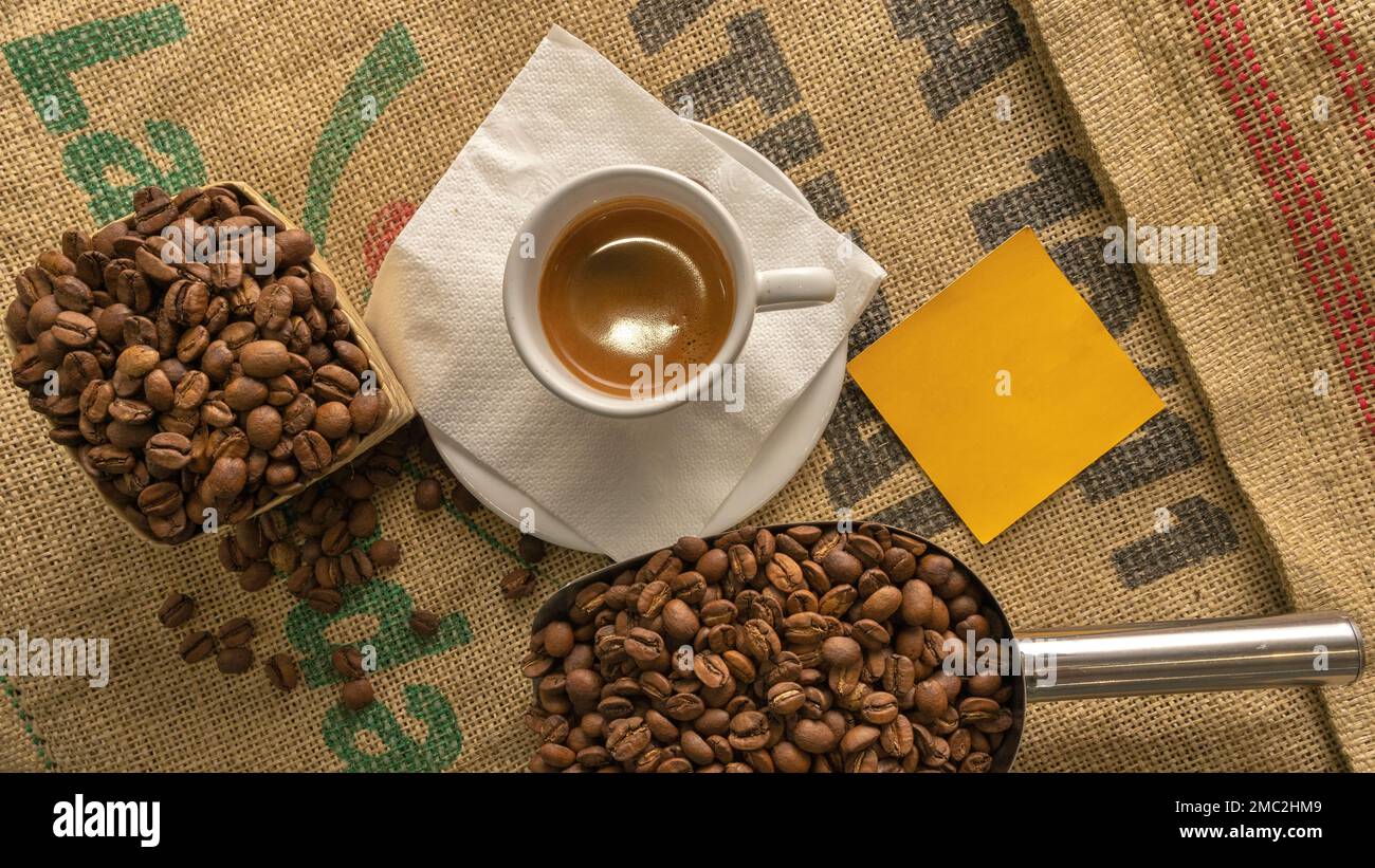 tasse Kaffee und Kaffeebohnen von oben mit leerem Post, um einen Satz oder Ihr eigenes Logo zu schreiben Stockfoto