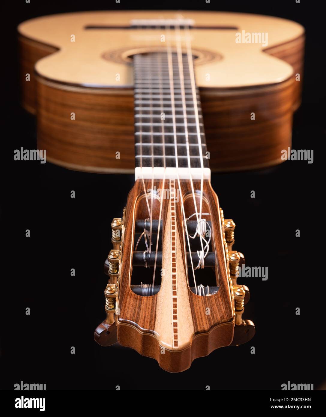 Klassische Gitarrenkopfstock-Details auf schwarzem Hintergrund. Klassisches Akustikgitarrenkonzept. Perfekt für Flyer, Karten, Poster oder Tapeten Stockfoto