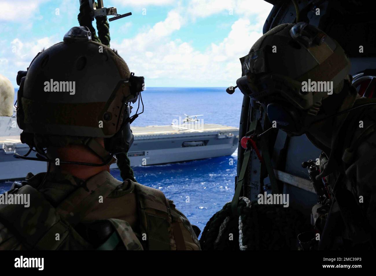 PAZIFIK (24. Juni 2022) Seeleute, die der mobilen Einheit für die Entsorgung von Explosivstoffen (EODMU) 3 zugeteilt wurden, beobachten Seeleute, die sich aus der Kabine eines MH-60s Seahawk-Hubschraubers, der den ‚Chargers‘ des Hubschraubergeschwaders Sea Combat Squadron (HSC) 14 zugeteilt wurde, während eines Hubschrauberbesuchs, an Bord, Durchsuchungs- und Beschlagnahmungsübung (hvbss) in Zusammenarbeit mit der Abraham Lincoln Carrier Strike Group (ABECSG) und dem Helikopterzerstörer der japanischen Selbstverteidigungskräfte JS Izumo (DDH-184). ABECSG führt derzeit Routineeinsätze in der US-3.-Flotte durch. Ein integraler Bestandteil der USA Pacific Fleet, USA 3. Fleet führt Stockfoto