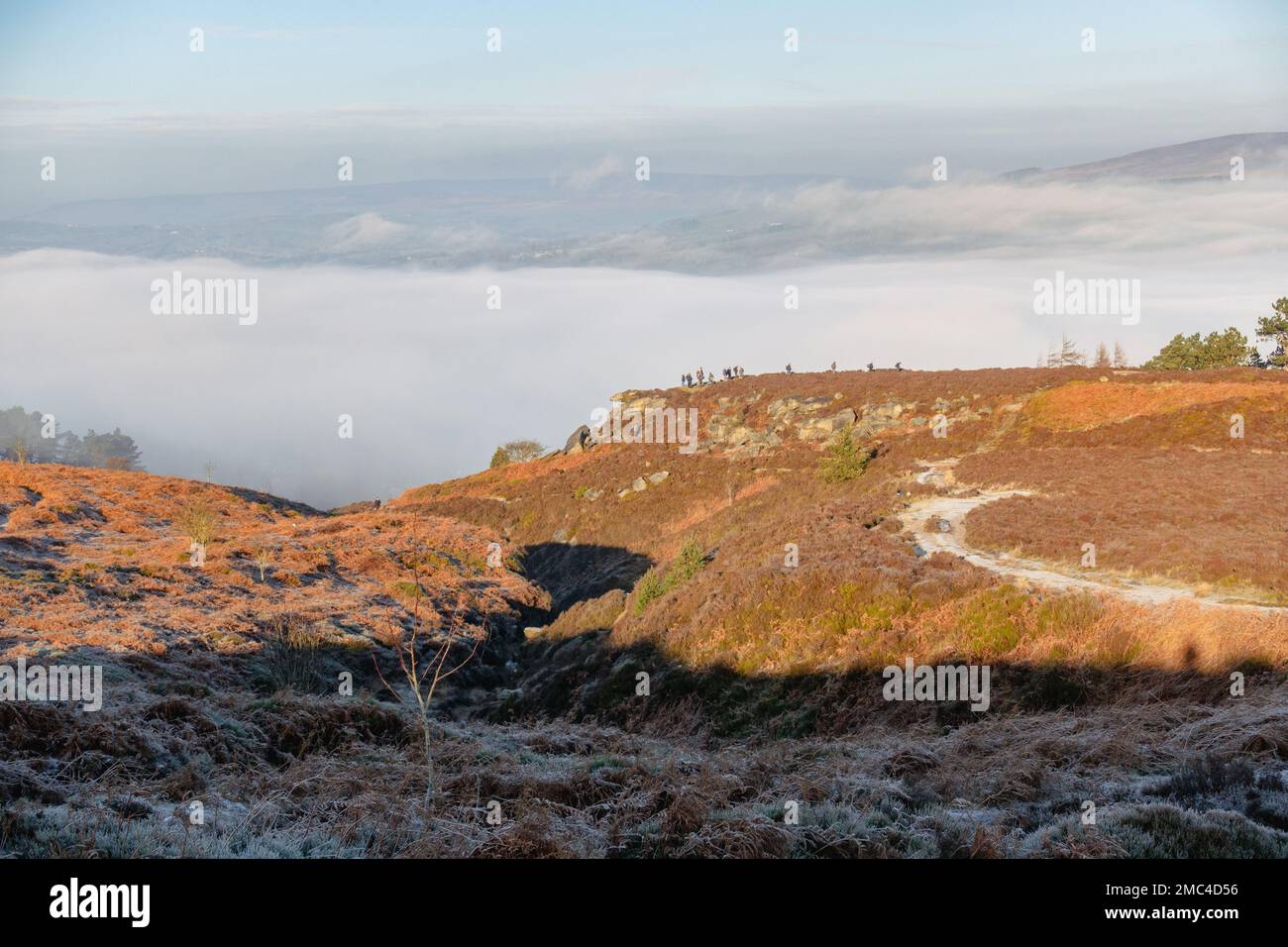 21. Januar 2023: Eine Gruppe von Menschen steht auf, um ihr gespenst von brocken aus dem steilen Tal zu beobachten, während sich der Nebel in Wharfedale zu einer Wolkeninvertierung aufbaut. Ilkley Moor, Ilkley, West Yorkshire, England, Großbritannien Kredit: Rebecca Cole/Alamy Live News Stockfoto