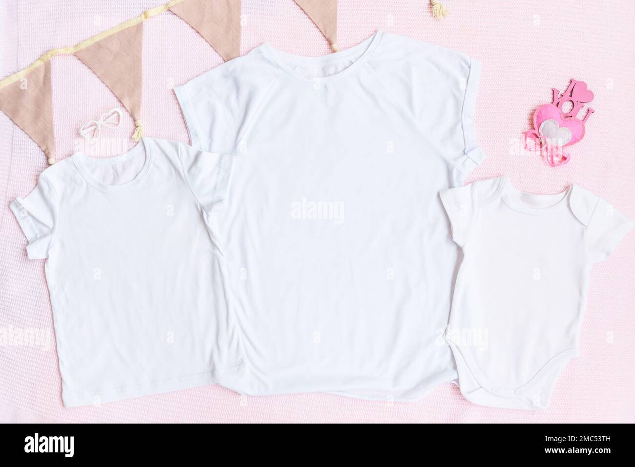 Muttertag weißes Modell-T-Shirt und Einteiler mit Herz auf pinkfarbenem Hintergrund für eltern und Kinder Stockfoto