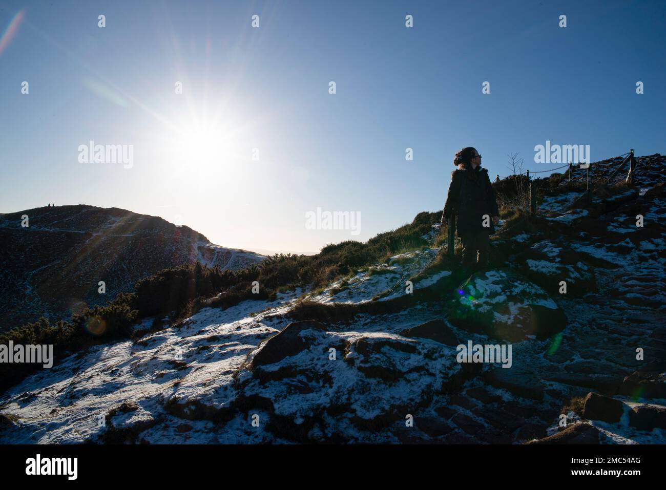 Ein Wanderer, der einen steilen und rutschigen Pfad an einem Wintertag bewertet Stockfoto