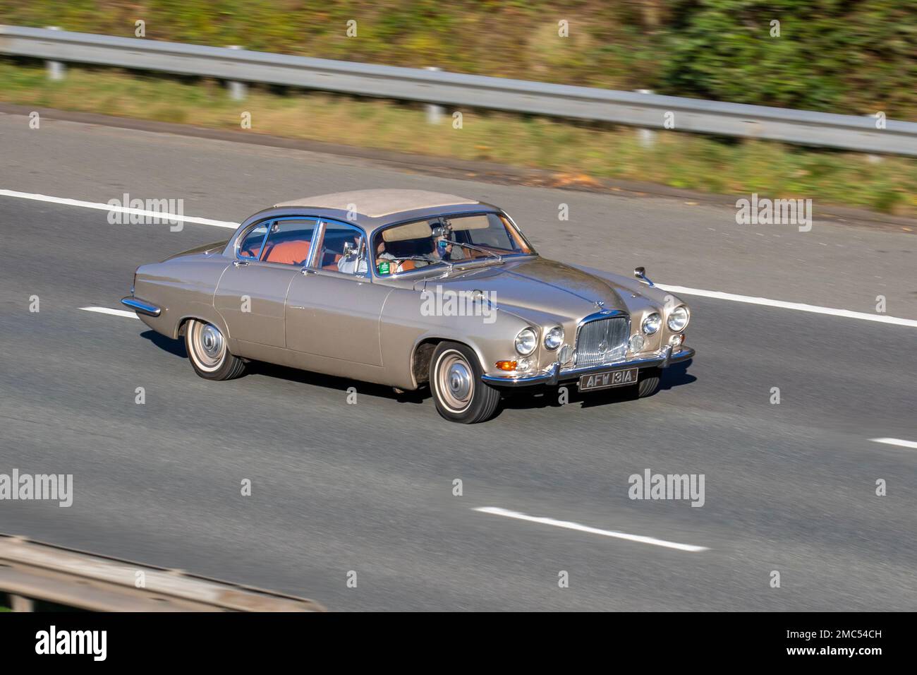 1963 60er Jahre Gold JAGUAR MK X 3781 ccm britische Luxuslimousine; Fahrt auf der Autobahn M61, Großbritannien Stockfoto