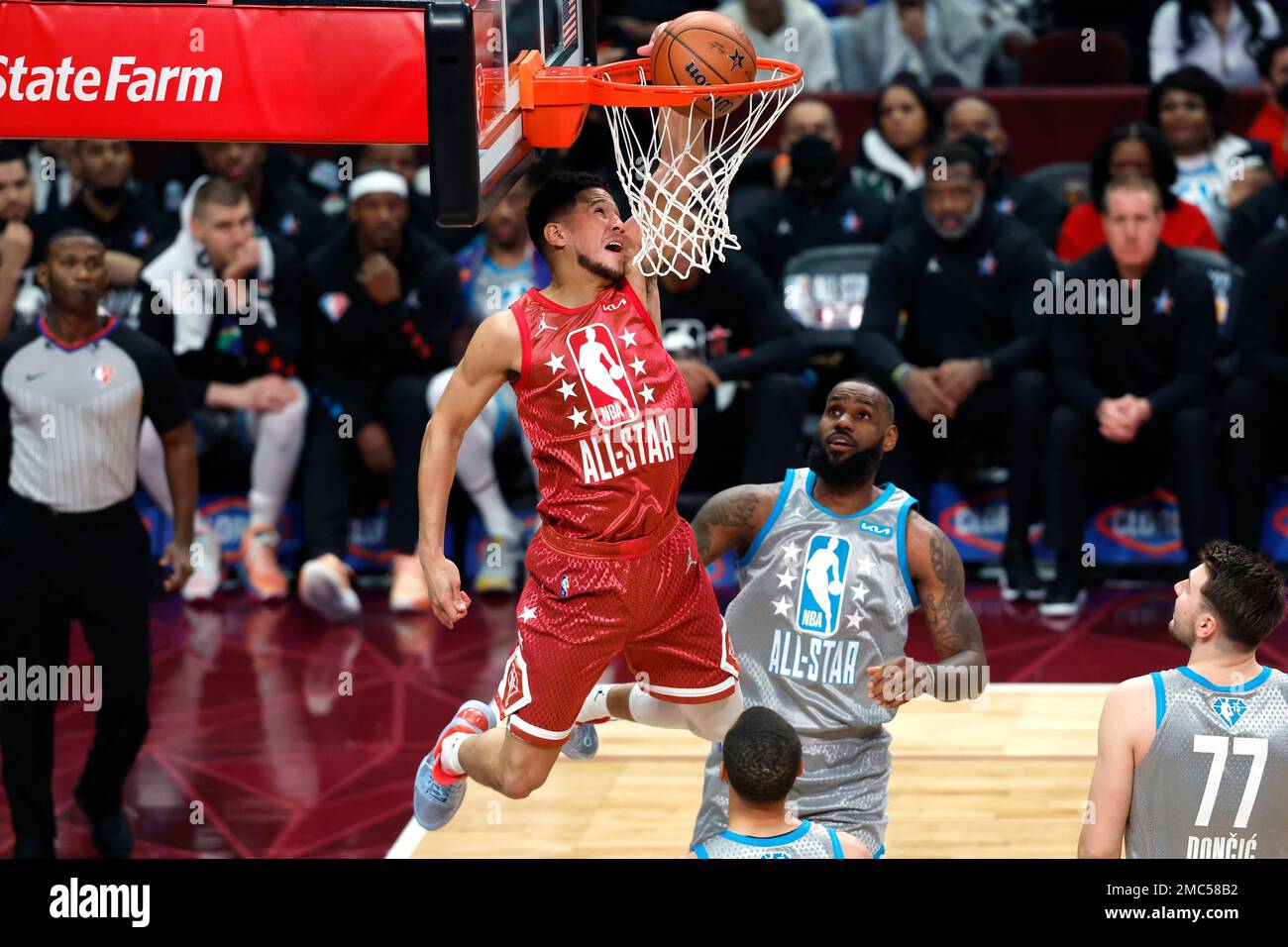 Phoenix Suns' Devin Booker dunks against Los Angeles Lakers' LeBron James during the second half of the NBA All-Star basketball game, Sunday, Feb. 20, 2022, in Cleveland. (AP Photo/Ron Schwane) Stockfoto
