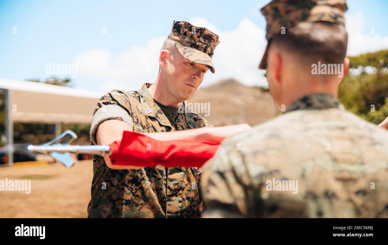 USA Marine Corps 1., Sergeant Billy Thomas, Battery First Sergeant, mit Air Control Battery, Littoral Anti-Air Battalion, 3D Marine Littoral Regiment, enthüllt Batterie Guidon zusammen mit Batterie Commander, Major Robert O'Neil, während der Zeremonie zur Batterieaktivierung an Bord der Marine Corps Basis Hawaii am 24. Juni 2022. Air Control Battery ist die zweite von vier Batterien, die unter dem 3D Littoral Anti-Air-Bataillon aktiviert werden. Stockfoto