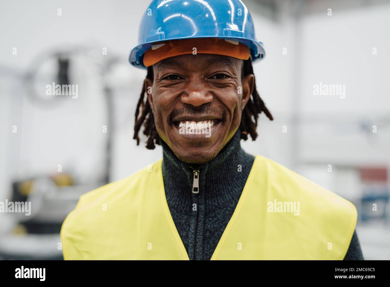 Glücklicher afrikanischer Ingenieur in der Automatisierungsfabrik - Industriekonzept Stockfoto