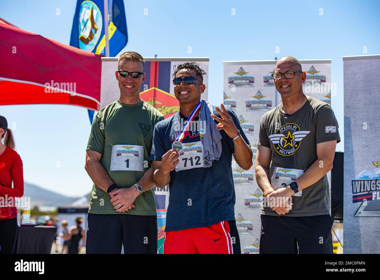 USA Marinekorps Oberst Thomas M. Bedell, links, Und Sergeant Maj Jason R. Cain, richtig, der befehlshabende Offizier und Sergeant Major der Marine Corps Air Station Miramar, posiert mit einem Marine, der in den Top 3 seiner Altersgruppe während der Wings Over Miramar Flug 5k auf MCAS Miramar, San Diego, Kalifornien, am 25. Juni 2022 war. Die Veranstaltung umfasste auch Aktivitäten, Verkäufer, Food Trucks und Gelegenheiten für die Teilnehmer, sich mit Marines, Matrosen zu treffen und Erinnerungsstücke von den Geschwadern der Flugstation zu kaufen. Stockfoto