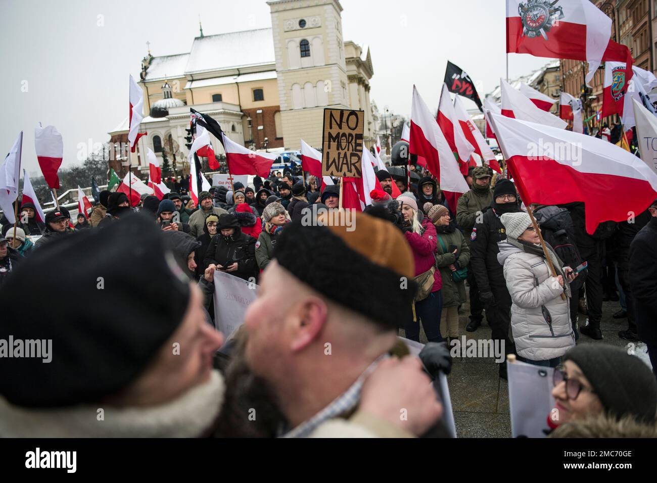 Warschau, Polen. 21. Januar 2023. Demonstranten halten während des marsches in Warschau Plakate und schwenken polnische Flaggen. Hunderte von Menschen nahmen an einem Anti-kriegsmarsch unter dem Slogan "This is not our war" Teil, der von einer nationalistischen Gruppe namens Landsleute (Rodacy Kamraci) organisiert wurde, um gegen die Beteiligung der polnischen Regierung am Konflikt in der Ukraine zu protestieren. Die Organisation Landsleute Genossen wird in Polen von vielen als pro-russische Gruppe betrachtet. Kredit: SOPA Images Limited/Alamy Live News Stockfoto