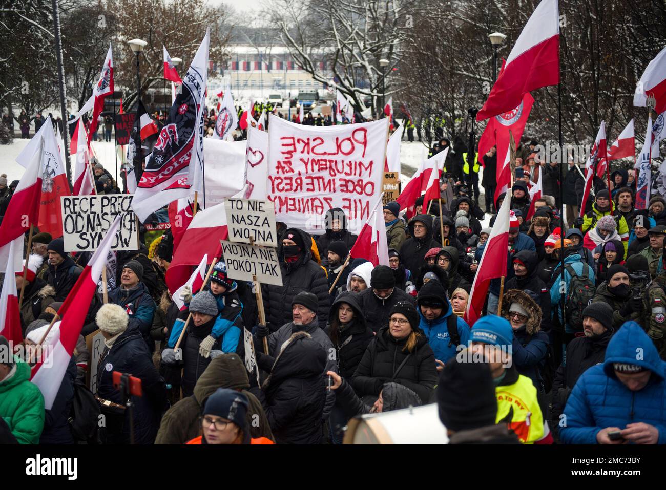 Warschau, Polen. 21. Januar 2023. Demonstranten halten während des marsches in Warschau ein Banner und schwenken polnische Flaggen. Hunderte von Menschen nahmen an einem Anti-kriegsmarsch unter dem Slogan "This is not our war" Teil, der von einer nationalistischen Gruppe namens Landsleute (Rodacy Kamraci) organisiert wurde, um gegen die Beteiligung der polnischen Regierung am Konflikt in der Ukraine zu protestieren. Die Organisation Landsleute Genossen wird in Polen von vielen als pro-russische Gruppe betrachtet. (Foto: Attila Husejnow/SOPA Images/Sipa USA) Guthaben: SIPA USA/Alamy Live News Stockfoto