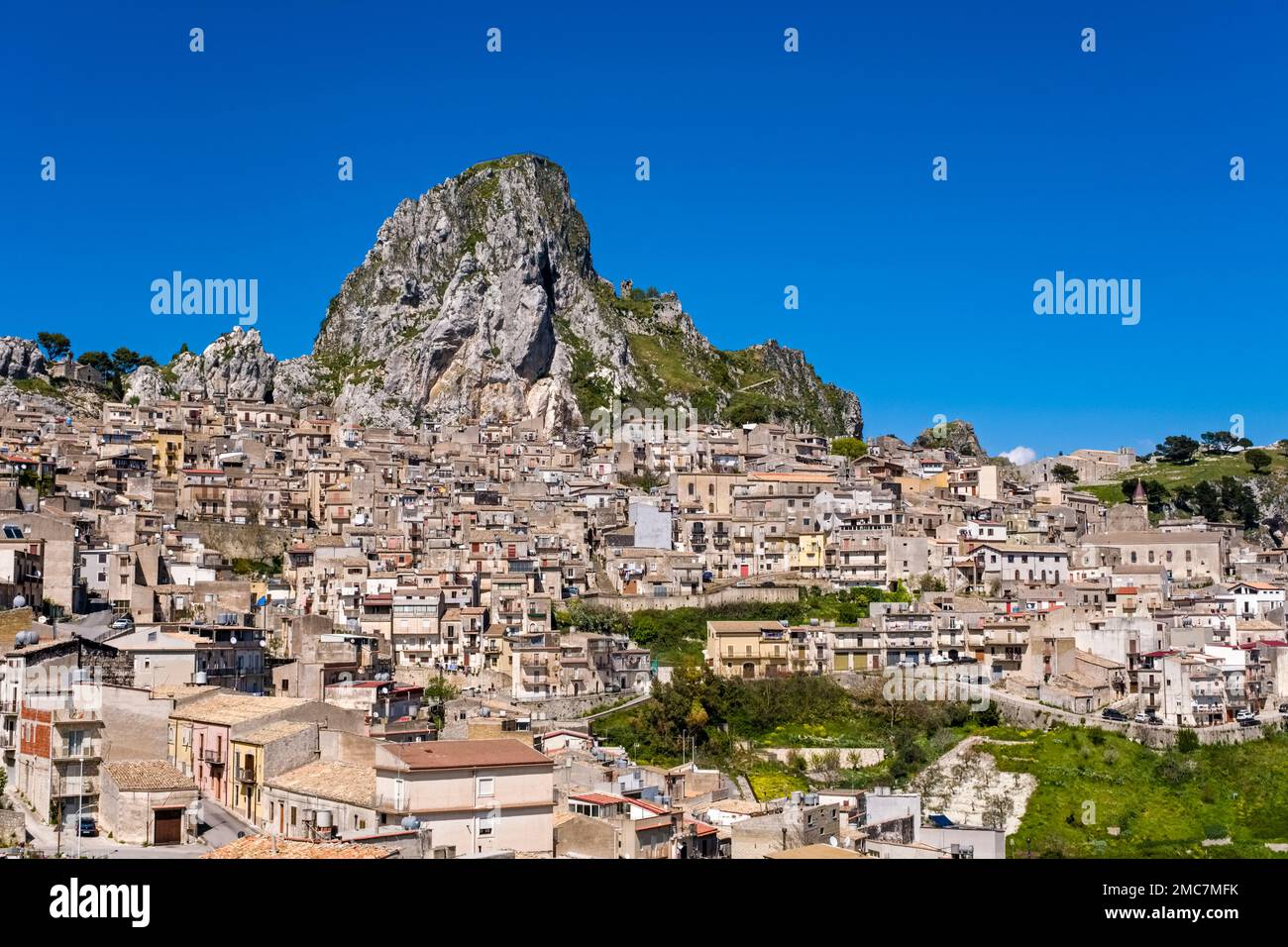 Blick auf die Häuser der kleinen Stadt Caltabellotta, die sich an einem Hang um einen Felsen befindet. Stockfoto