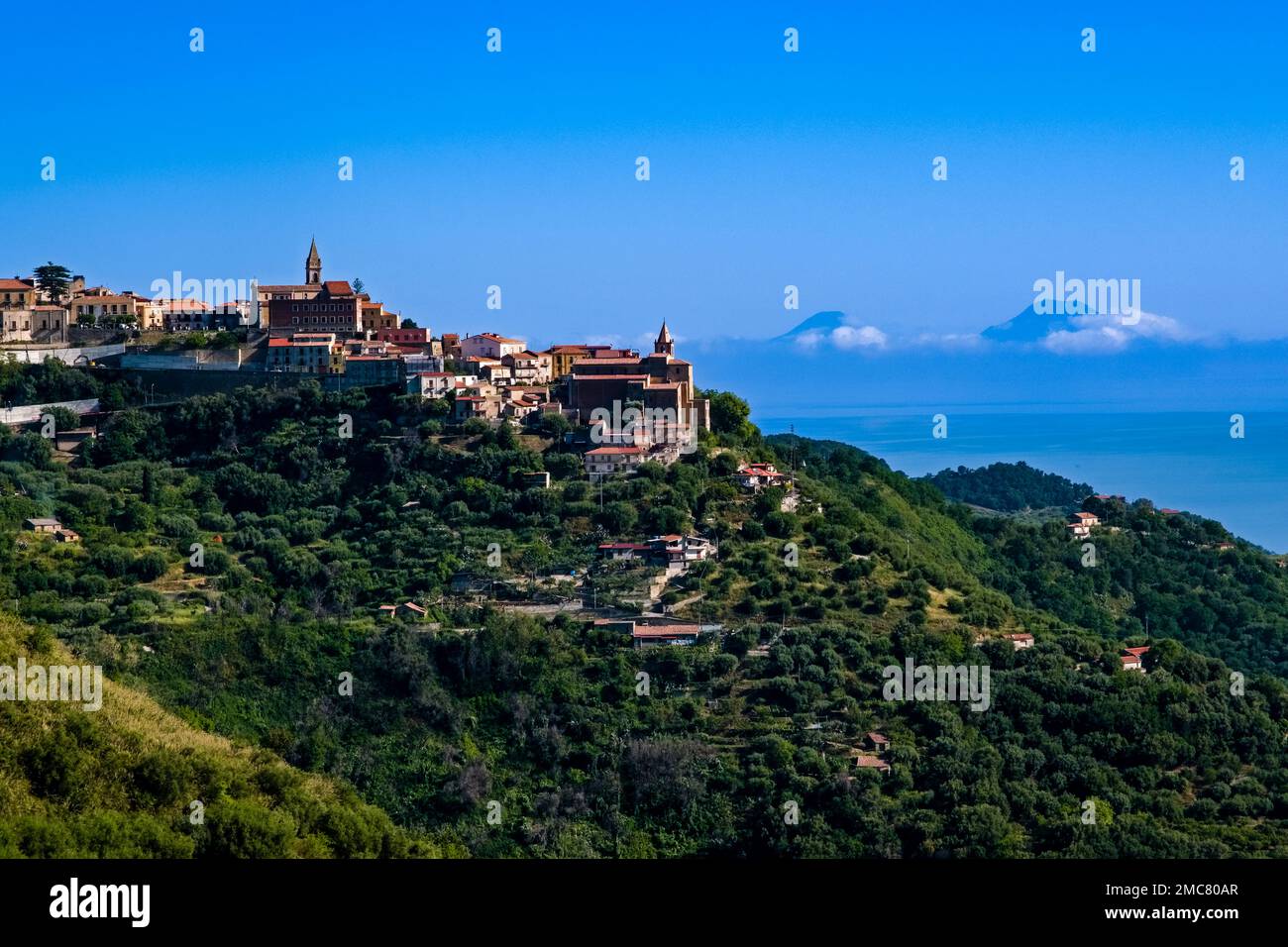 Blick auf die Häuser der kleinen Stadt Naso, hoch oben auf einem Hügel, die Lipari-Inseln in der Ferne. Stockfoto
