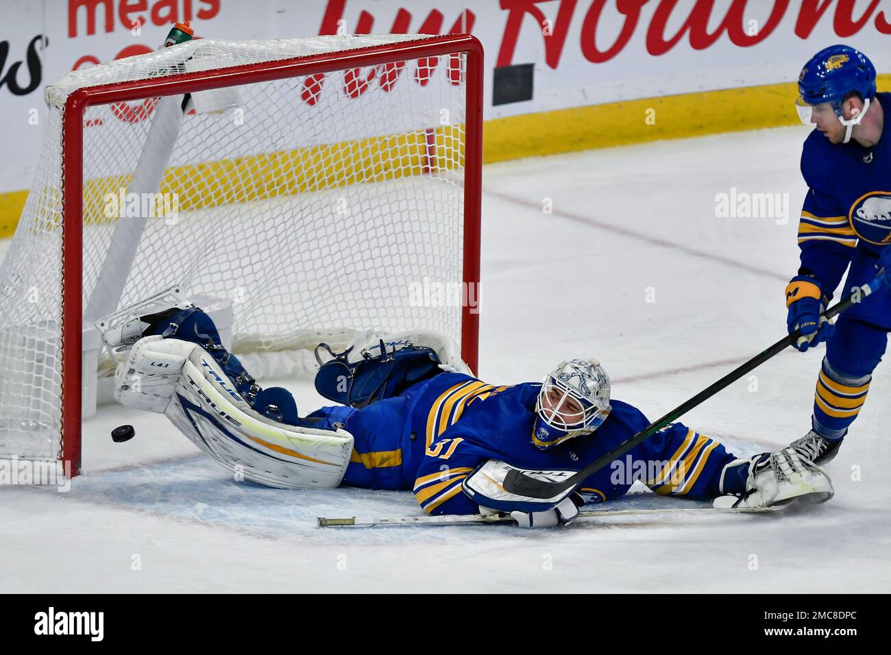 Buffalo Sabres Goalie Dustin Tokarski, Left, Looks Back As The Puck ...