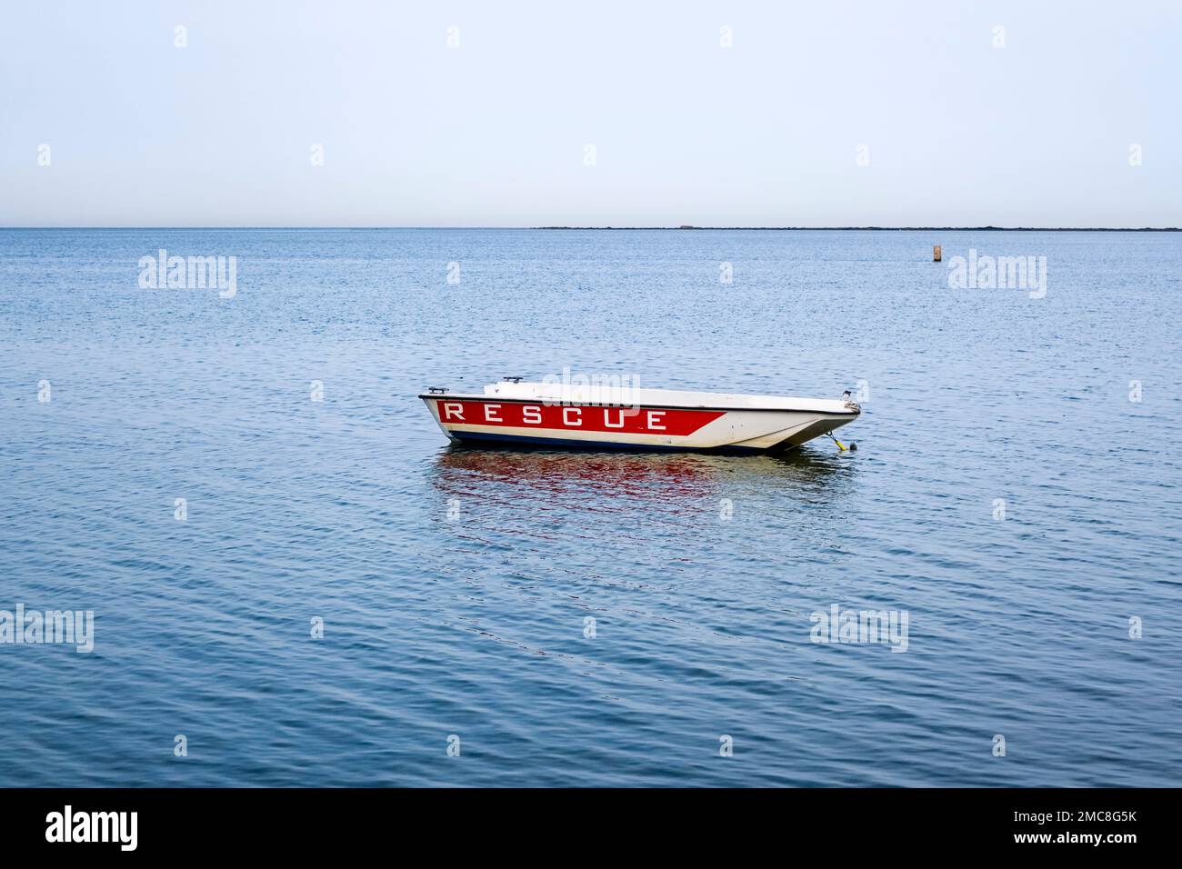 Ein verlassenes Rettungsboot ist im Meer verankert. Stockfoto