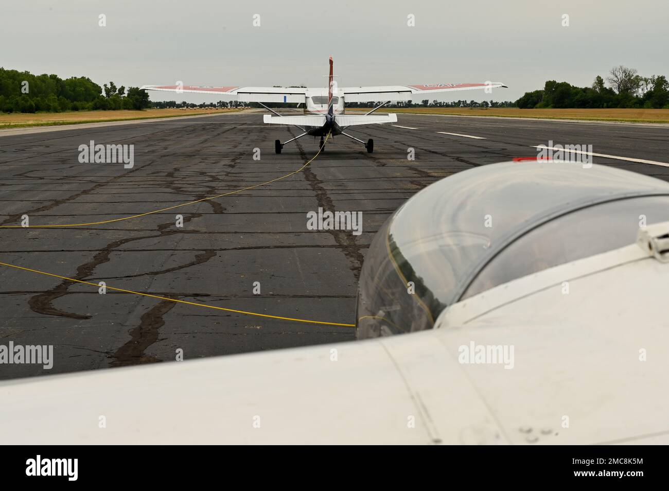 Ein Cessna 182 Skylane bereitet sich darauf vor, am 27. Juni 2022 am Sunflower Gliderport in Hutchinson, Kansas, einen L-23 Super Blanik Glider in die Luft zu holen. Die Cessna zieht den Gleiter mit einem Führungsseil in die Luft und lässt ihn wieder los, sobald der Gleiter eine Geschwindigkeit erreicht hat, die hoch genug ist, um genügend Auftrieb zu halten, um in der Luft zu bleiben. Stockfoto