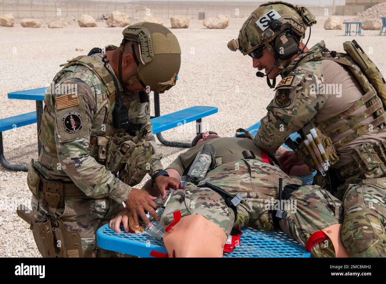 USA Air Force Tech. Sergeant Edward Lopez und U.S. Air Force Tech. Sgt. Johnathan Finer, 379. Geschwader der Expeditionstruppen, erste Hilfe für ein Opfer einer simulierten Explosion während einer Übung auf dem Al Udeid Luftwaffenstützpunkt, Katar, 27. Juni 2022. Das simulierte Opfer hatte massive Blutungen aus beiden Beinen. Stockfoto