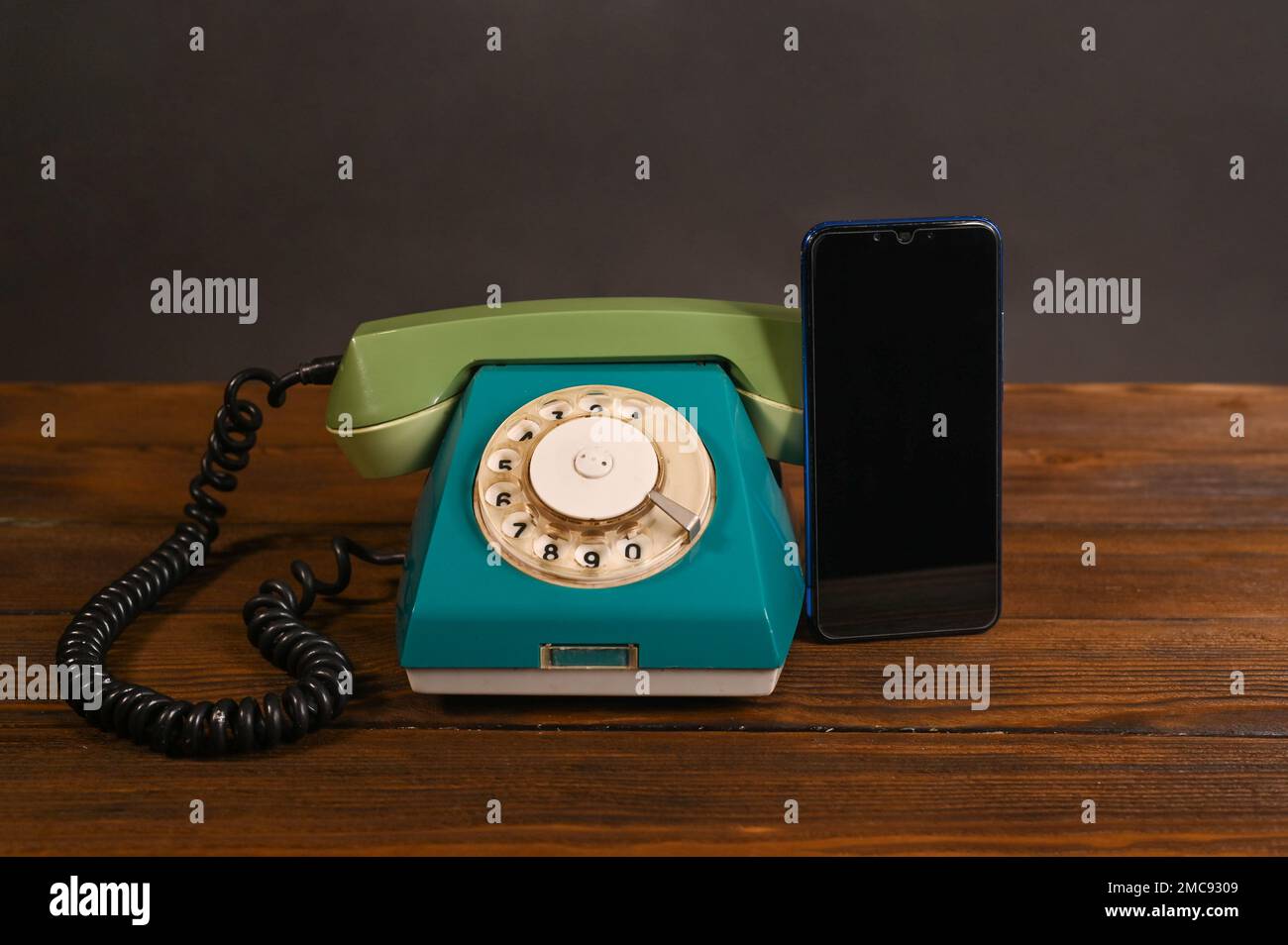 Ein altes kabelgebundenes Telefon und ein modernes Smartphone Stockfoto