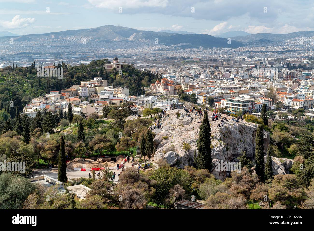 Panoramablick auf Athen von der Akropolis aus. Die Menschen auf dem Areopagus Hill genießen den Blick auf Athen, das alte Nationale Observatorium Stockfoto