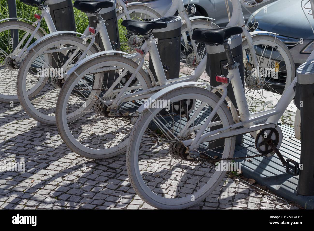 Räder geparkter Fahrräder auf dem Fahrradverleih-Parkplatz. Fahrradverleih. Der Fahrradverleih ist günstig. Fahrradparkplatz. Gemeinsame Form der Öffentlichkeit Stockfoto