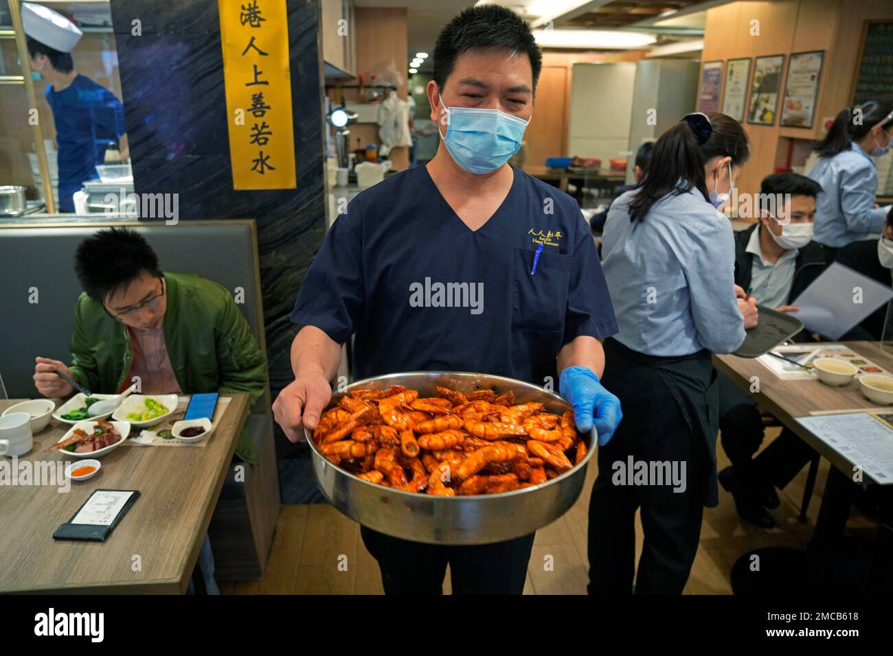 Poon Choi Chef Fong Wahyat carries a bucket of prawns while making the