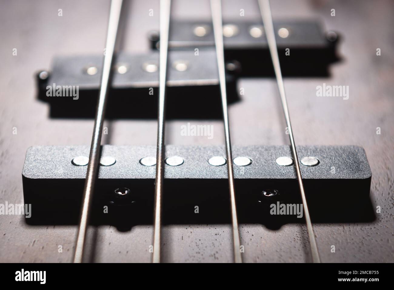 Bass E-Gitarre mit vier Saiten Nahaufnahme. Detail des populären Rock Musikinstruments. Nahansicht des Elements aus Holz texturierten Bass. Vintage Macr Stockfoto
