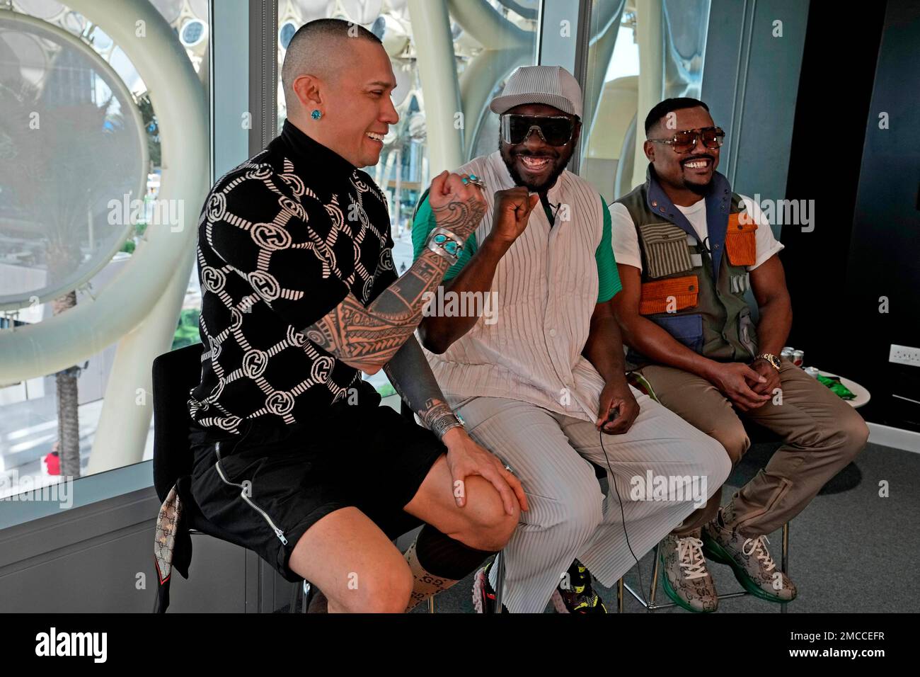 Taboo, 1st left, gives a fist pump to will.i.am, as apl.de.ap, looks on, from Black Eyed Peas during an interview with The Associated Press ahead of their concert tomorrow at the Dubai Expo Dubai, United Arab Emirates, Monday, Jan. 24, 2022. (AP Photo/Kamran Jebreili) Stockfoto