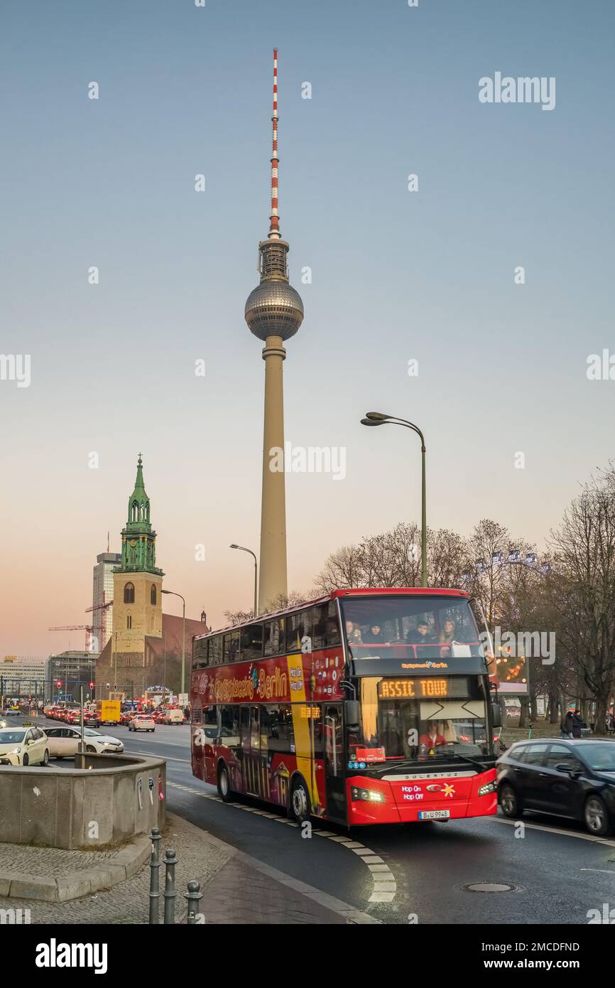 Touristischer Doppeldecker Hop-on-Hop-off-Bus mit berühmtem Fernsehturm im Hintergrund in Berlin, Deutschland. Stockfoto