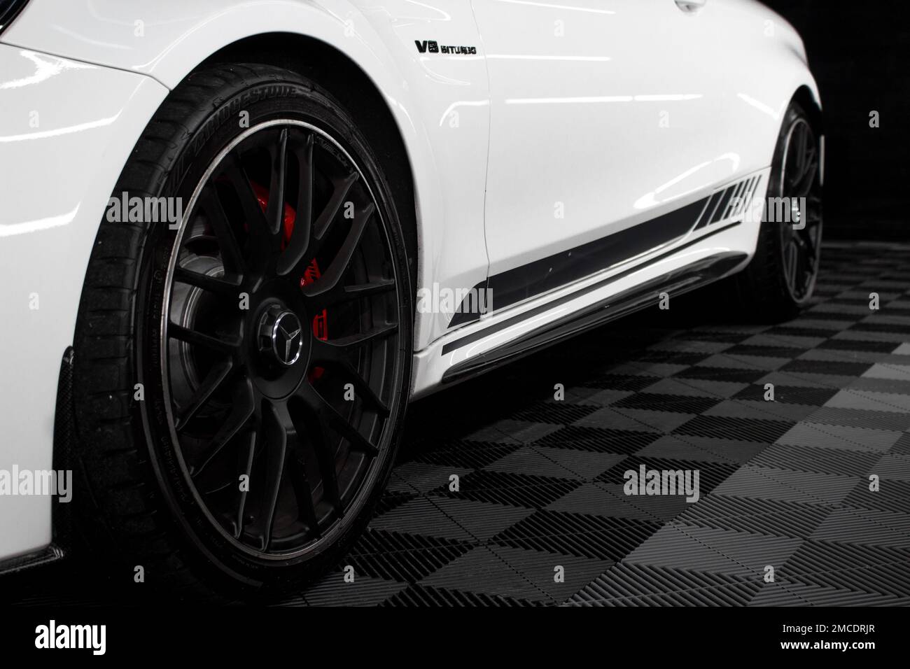 Das hintere Leichtmetallrad in glänzend Schwarz bei Einem Mercedes Benz C63s AMG W205 Edition 2016 1 in Weiß mit schwarzen AMG-Seitenstreifen Stockfoto