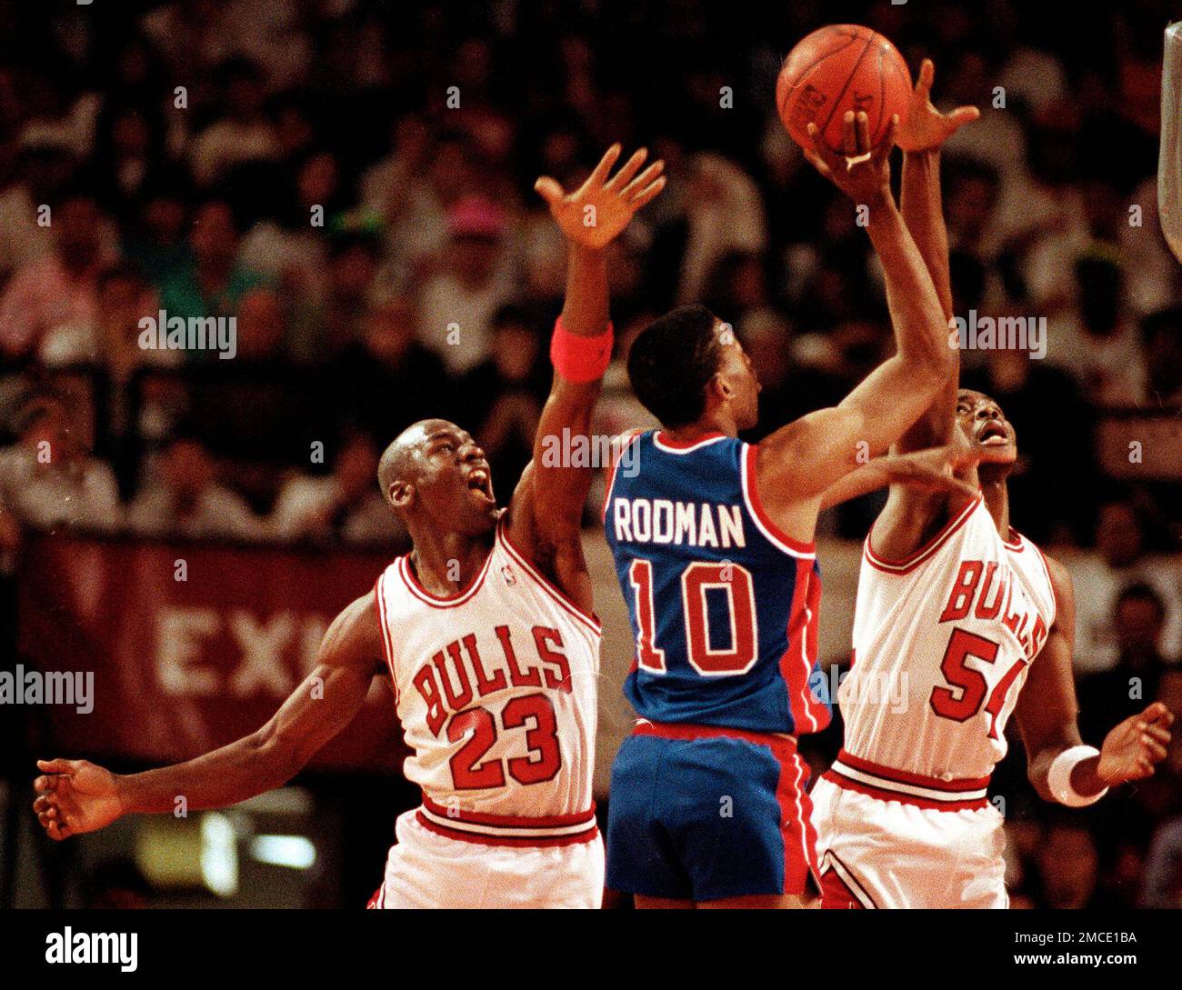 FILE - Chicago Bulls teammates Michael Jordan (23) and Horace Grant (54) put double coverage on Detroit Pistons' Dennis Rodman (10) in the second quarter of their Eastern Conference final playoff Game 3 in Chicago, Ill., May 27, 1990. (AP Photo/Jim Mone, File) Stockfoto