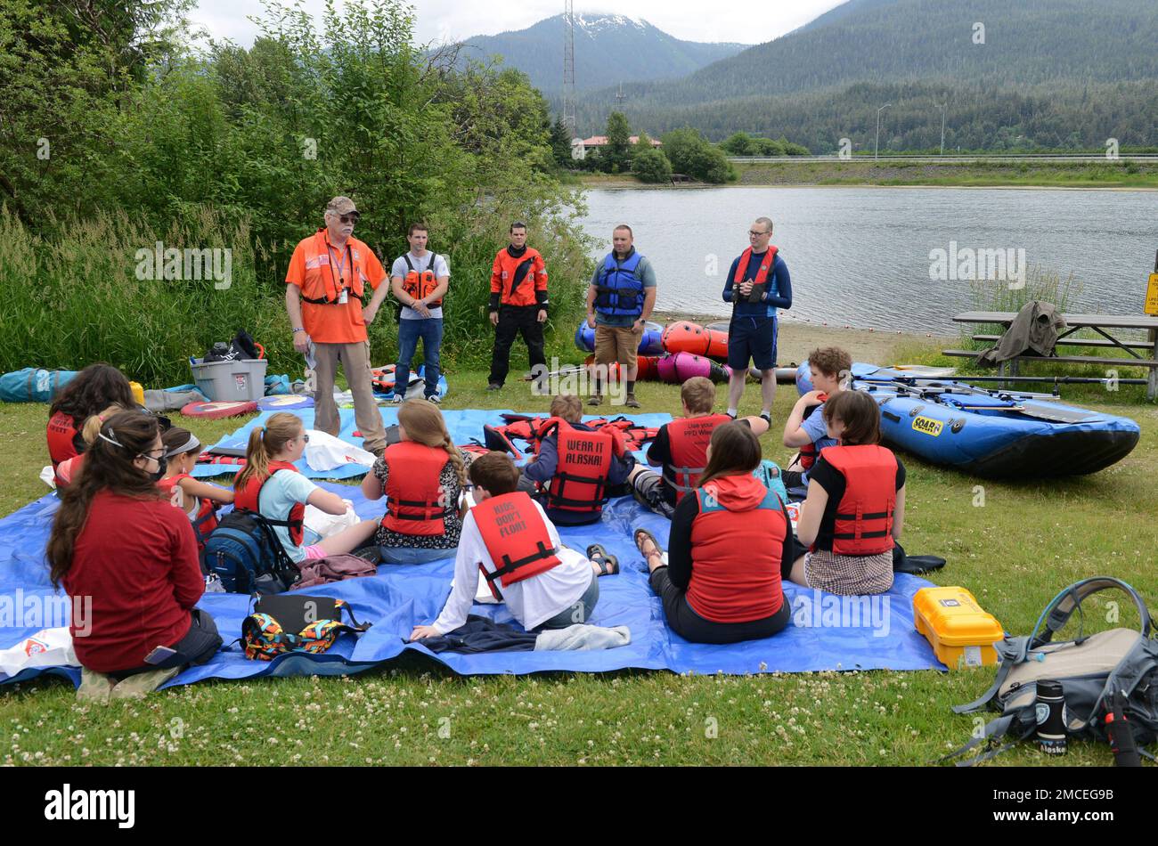 Mitarbeiter der Küstenwache unterhielten sich mit Kindern in Twin Lakes während einer Kids Don't Float Trainingsveranstaltung in Juneau, Alaska, am 30. Juni 2022. Mitarbeiter von Coast Guard Sector Juneau, Coast Guard Station Juneau und dem 17. Coast Guard District haben sich mit Southeast Discovery zusammengetan, um dem Sommercamp-Kurs Schwimmwesten, Bootssicherheit und die Verwendung verschiedener Arten von Paddelbooten beizubringen. - AUS DEN USA Foto der Küstenwache von Petty Officer 2. Klasse Lexie Preston Stockfoto