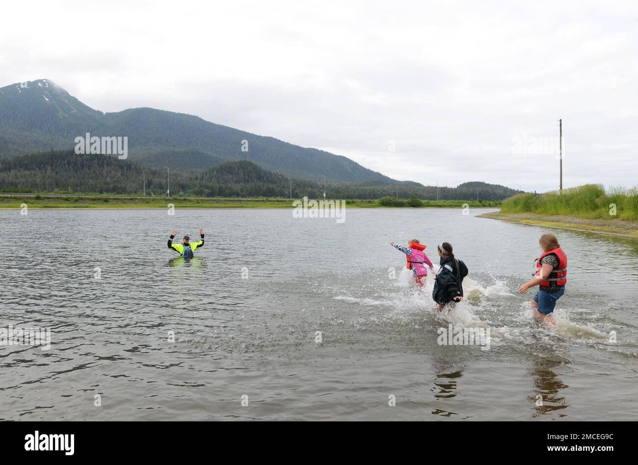 Kinder tragen Schwimmwesten, während sie zu einem Sicherheitslehrer der Küstenwache in Twin Lakes während einer Kids Do't Float Trainingsveranstaltung in Juneau, Alaska, am 30. Juni 2022 laufen. Mitarbeiter von Coast Guard Sector Juneau, Coast Guard Station Juneau und dem 17. Coast Guard District haben sich mit Southeast Discovery zusammengetan, um dem Sommercamp-Kurs Schwimmwesten, Bootssicherheit und die Verwendung verschiedener Arten von Paddelbooten beizubringen. - AUS DEN USA Foto der Küstenwache von Petty Officer 2. Klasse Lexie Preston Stockfoto