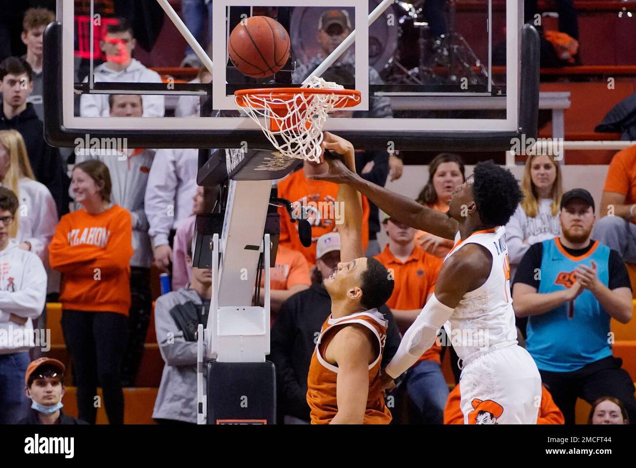 Texas forward Dylan Disu, left, goes up for a dunk but misses as Oklahoma State guard Bryce Williams, right, defends, in the second half of an NCAA college basketball game Saturday, Jan. 8, 2022, in Stillwater, Okla. (AP Photo/Sue Ogrocki) Stockfoto