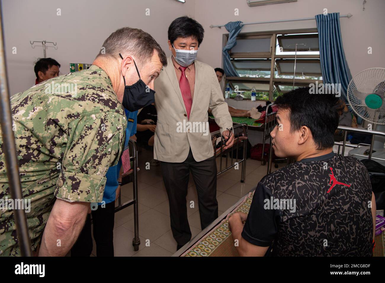 TUY HOA, Vietnam (29. Juni 2022) – Rear ADM. Mark Melson, Commander, Task Force 73 (CTF 73), Left, spricht mit einem Patienten im Phu Yen General Hospital während einer Führung durch das vietnamesische Krankenhaus zur Unterstützung der Pacific Partnership 2022. Die Pazifikpartnerschaft ist die größte multinationale Mission zur Vorbereitung auf humanitäre Hilfe und Katastrophenhilfe, die jährlich im Indo-Pazifik durchgeführt wird. Sie ist seit 17. Jahren Teil der Partnerschaft. Stockfoto