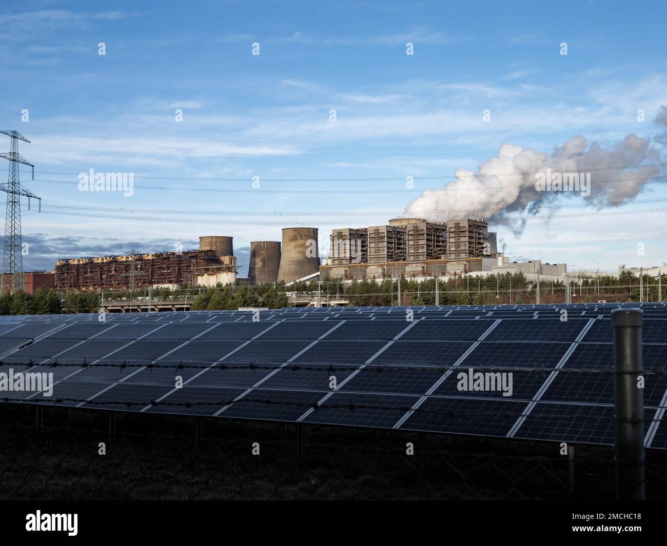 Solaranlage gegen ein altes Braunkohlekraftwerk. Erneuerbare Energien in Kombination mit konventioneller Technologie sind der Status quo. Kohlendioxid Stockfoto