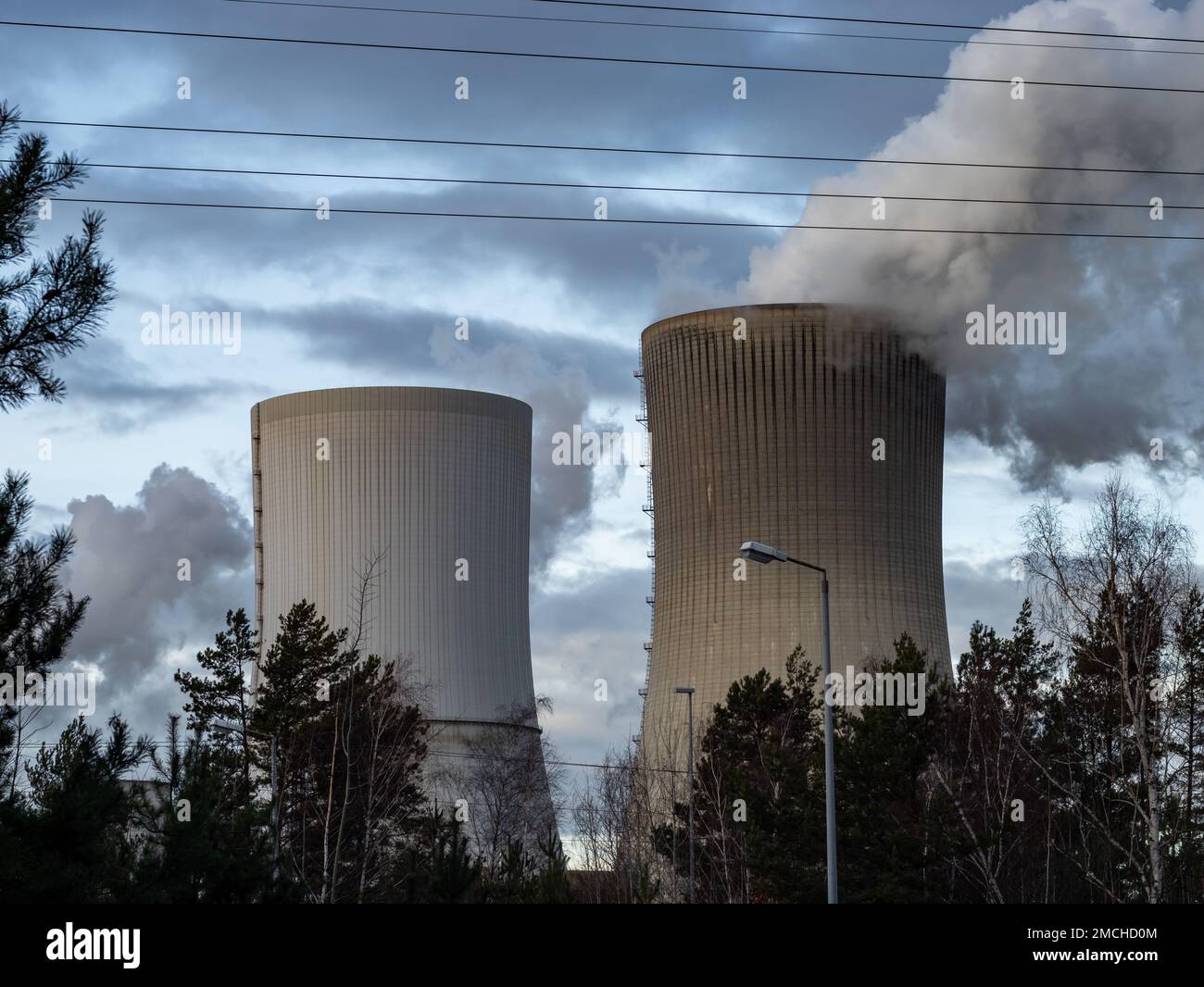 Dunkler Rauch aus einem Kraftwerk. Schornstein aus einem Kühlturm eines Braunkohlekraftwerks zur Energieerzeugung. Luftverunreinigung durch Menschen. Stockfoto