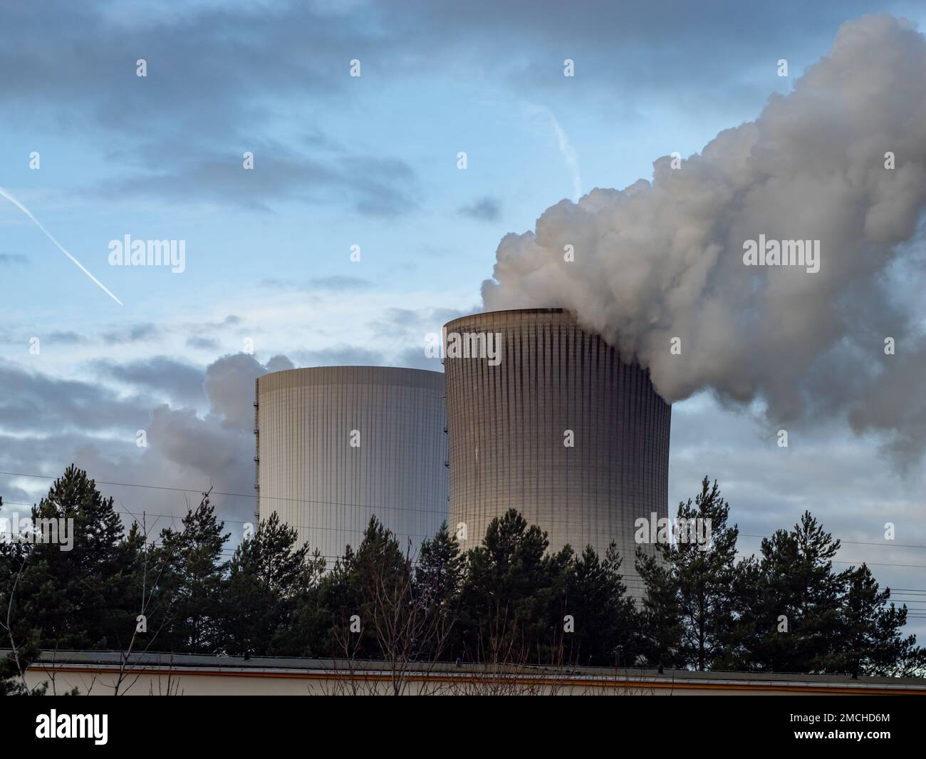 Dunkler Schornstein aus einem Kühlturm eines Kraftwerks verunreinigt die Luft. Umweltschäden durch die Industrie und CO2-Emissionen. Stockfoto