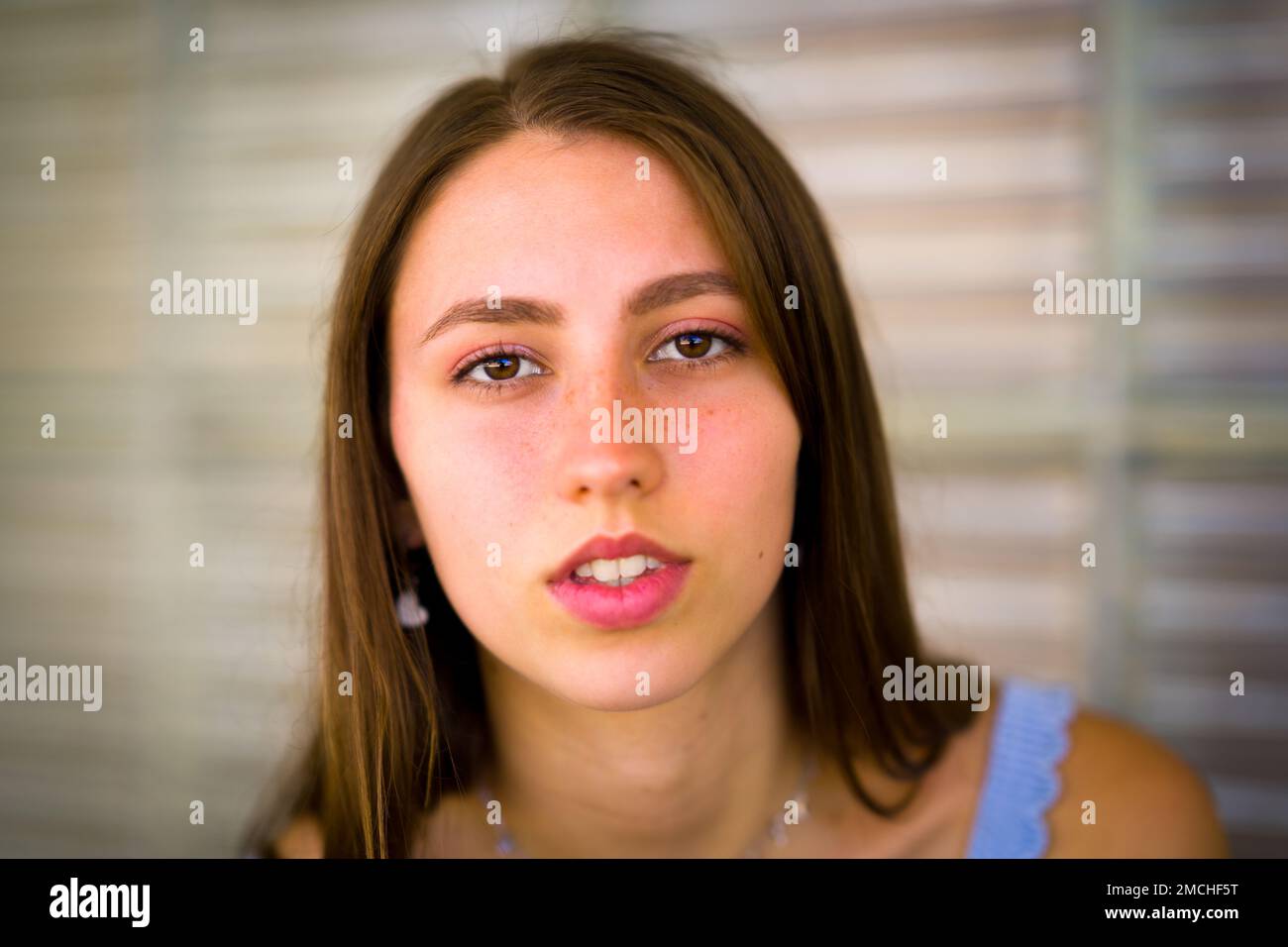 Nahaufnahme des Porträts von Teenage Girl, das sich gegen ein Art déco-Fenster aus Glas lehnt Stockfoto